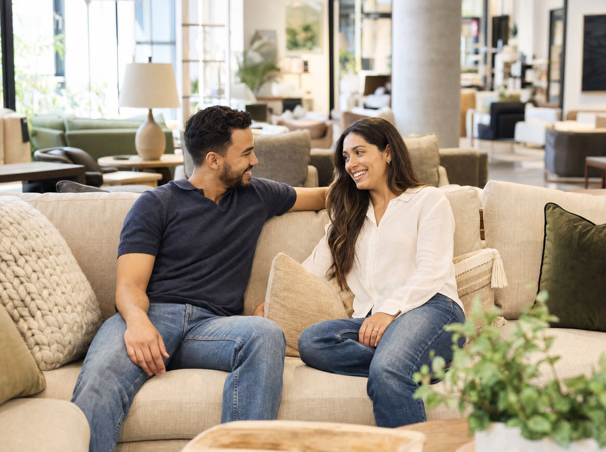 A couple trying out a sofa together inside a bright furniture showroom